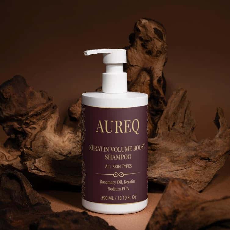 AUREQ Keratin Volume Boost Shampoo bottle on natural wood background, promoting fuller-looking hair.