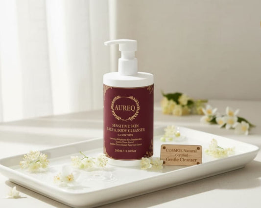 AUREQ Sensitive Skin Face & Body Cleanser bottle on a tray with flowers, promoting gentle care for sensitive skin.